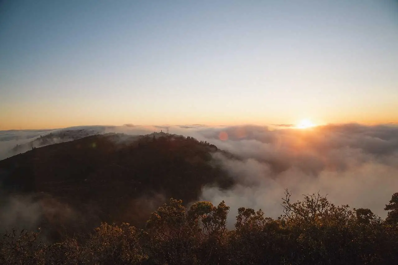Goldener Sonnenaufgang über nebelverhangenen Hügeln